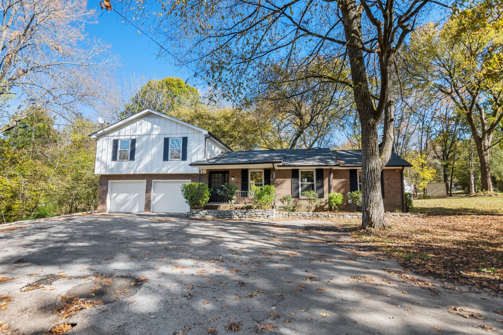 Front exterior of 1096 Weakley Lane, a brick split-level home on a wooded lot